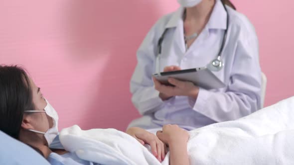 Doctor Wearing Face Mask Proficiently Talks with Patient at Hospital Ward