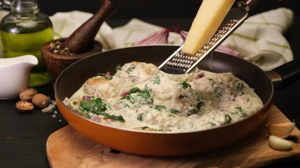 Delicious Small Meatballs with Spinach in a Creamy Sauce in the Frying Pan