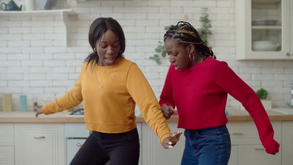 Active Black Teenage Girls Dancing in Domestic Kitchen