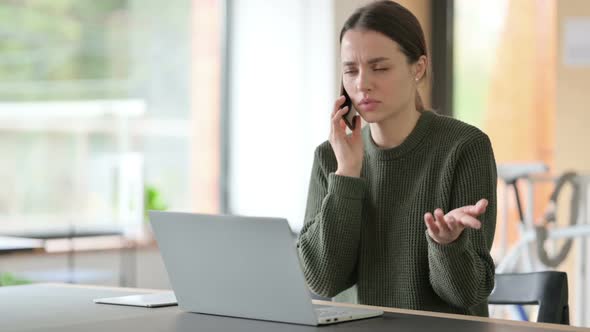 Angry Woman Talking on Phone at Work