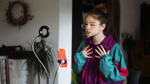 young influencer girl records video on her phone for social media at home