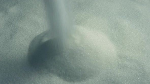 White Sugar Pouring Into Pile