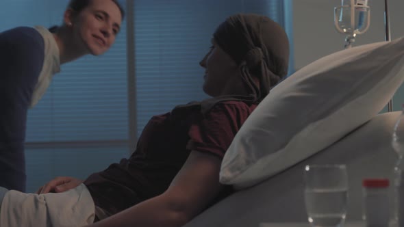 Caring woman hugging her friend with cancer at the hospital