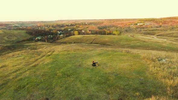 Girl and American Staffordshire Terrier Sitting in Countryside at Sunset