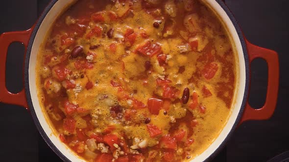 Step by step. Top view. Stirring turkey chili in enameled cast iron covered dutch oven.