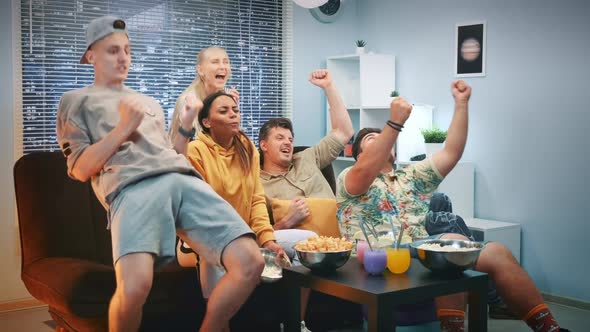 Multiracial Friends Watching Sports on TV and Spilling Popcorn When Team Scores