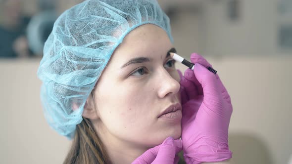 Girl Undergoes Applying Permanent Brow Makeup Procedure