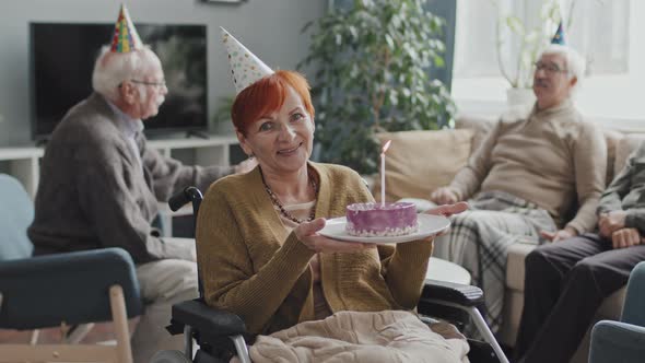 Portrait of Senior Woman with Birthday Cake in Wheelchair