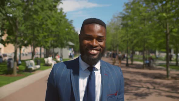 Close Up of Smiling African Businessman in Formal Wear Walking at City Park