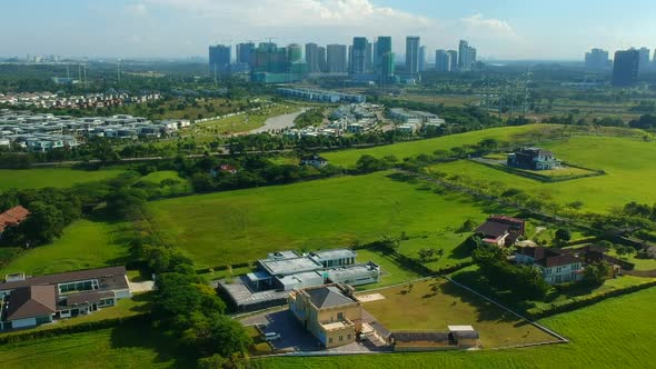 Aerial footage of a landscape with housing estate and blue sky in the background