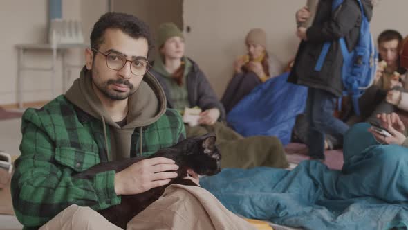 Portrait of Bearded Refugee Man with Homeless Cat in Asylum