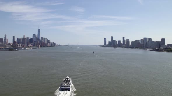 Revealing a ferry on Hudson river, summer in sunny New York, USA - Reverse Aerial