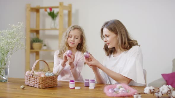 Mother and Daughter Putting Glitter Paint on Easter Eggs