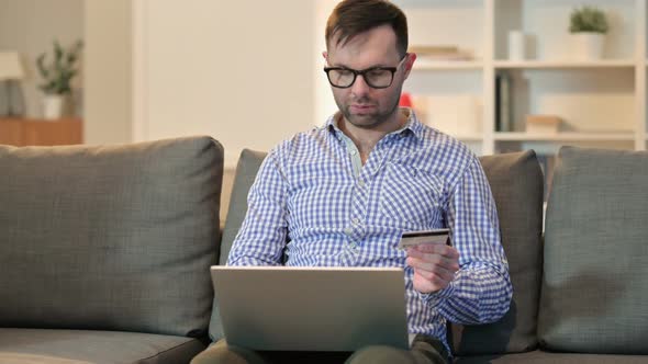 Successful Online Payment on Laptop By Young Man