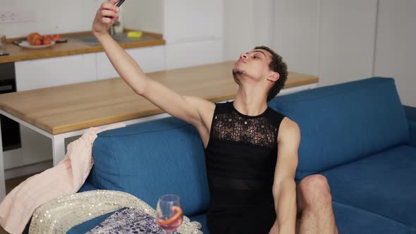Sensual Guy in Dress Doing Selfie with Mobile Phone on a Couch