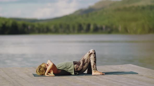 Woman Practicing Wheel Pose on Pier while Doing Yoga Outdoors