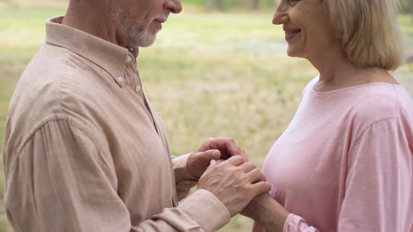 Happy Romantic Couple Holding Hands During Outdoor Date, Grandparents Love