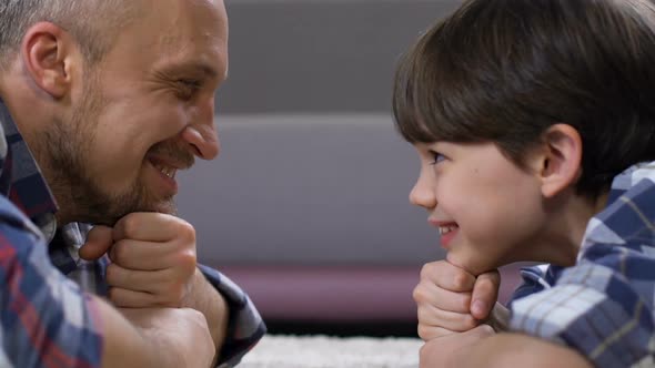 Father and Son Lying on Floor Chin on Hand and Looking Each Other, Family Love