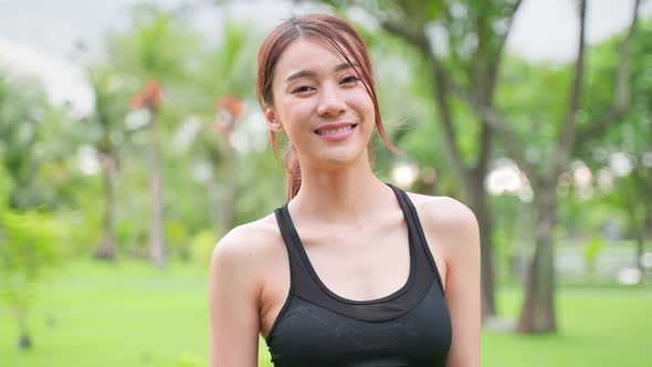 Asian active sport woman stand with confidence after exercise outdoors.