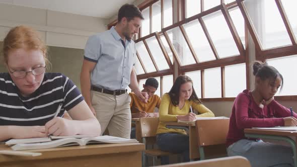 Teacher speaking to a high school student in class