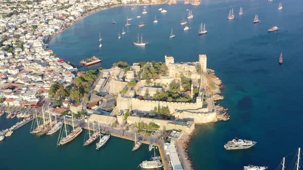 aerial of Bodrum Castle surrounded by the blue Aegean Sea with many boats anchored in the water on a