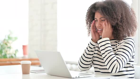 Stressed African Woman with Laptop Having Headache 