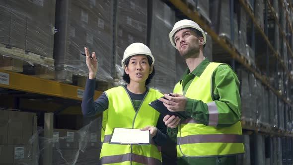 Young American Employees Having Conversation, Standing in Warehouse During Working Day.