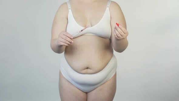 Obese Female in Lingerie Showing Insulin Syringe Before Camera, Diabetes Reasons