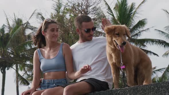 Couple Petting their Dog Outdoors