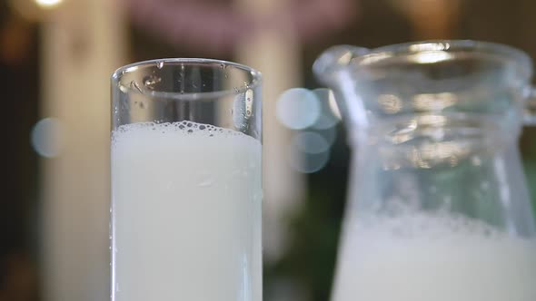 Slow Motion Glass With Fresh Milk. A Natural Dairy Product In A Glass Is Spinning On The Table.