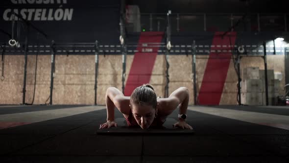 Young female doing planking exercise in gym