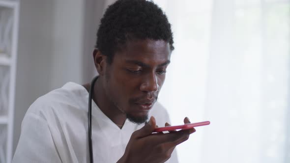 Headshot African American Doctor Recording Sending Voice Mail on Smartphone