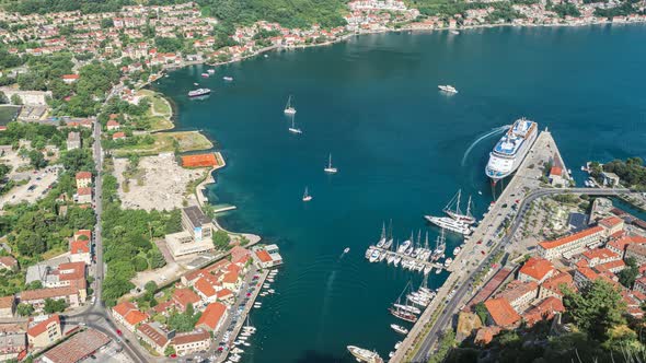 View from above to the Kotor city and cruise ship in Boka Kotor bay in windy weather, 4K time lapse