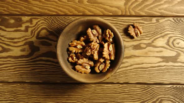 Peeled Walnuts Fall Into Wooden Cup