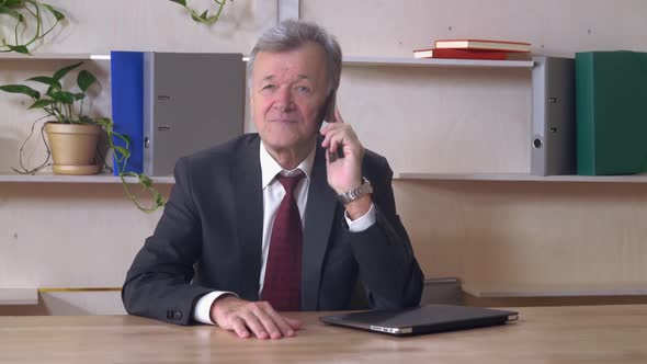 Aged Manager Using Cellphone Indoors