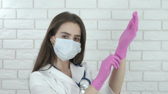 The girl doctor puts on gloves.