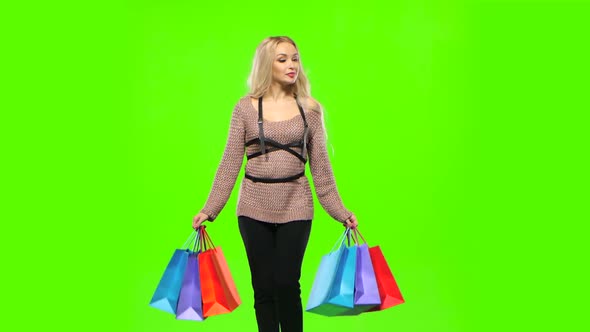 Girl in a Beautiful Dress Carries a Lot of Multi Colored Packages. Green Screen