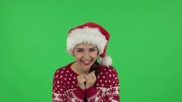 Portrait of Sweety Girl in Santa Claus Hat Is Laughing While Looking at Camera. Green Screen