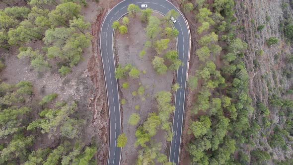 Aerial shot of a U turn road curve in the forest