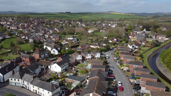 Aerial drone panning over rural village houses and football pitch, Exeter, England