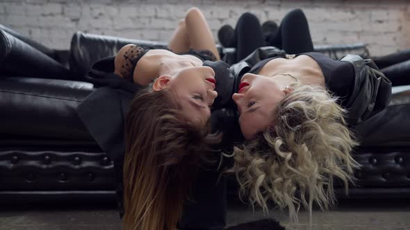 Loving Female LGBT Couple Lying Upside Down on Couch Looking at Each Other