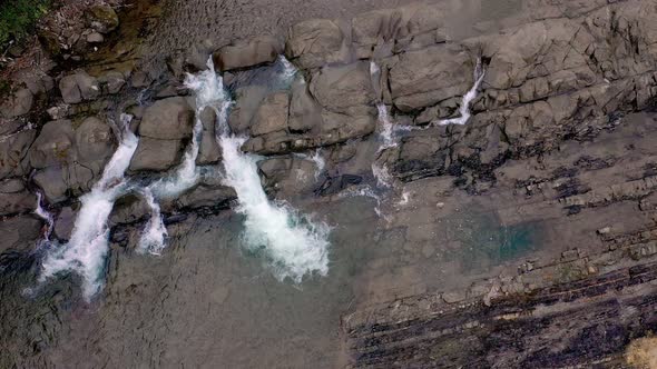 Aerial view of mountain river with cold clear water. The river flows over the stones