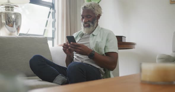 Video of happy african american senior man using smartphone