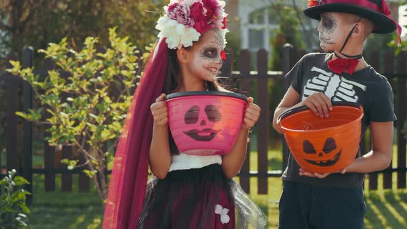 Little Friends in Halloween Costumes Posing Outdoors