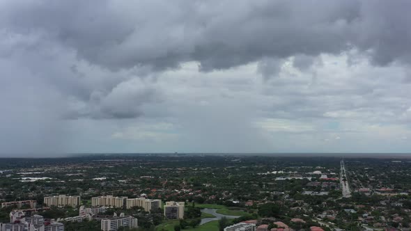 A high angle, aerial view over a quiet suburban neighborhood in Florida during a cloudy day. The cam