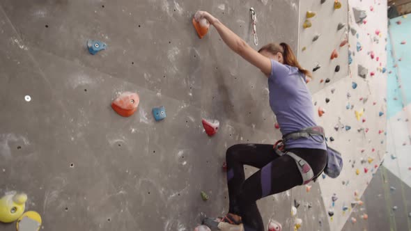 Female Athlete Practicing Bouldering in Gym