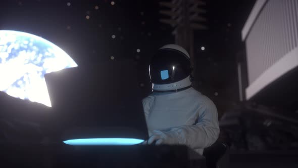 Astronaut Works on His Science Laptop in a Space Colony on the Moon