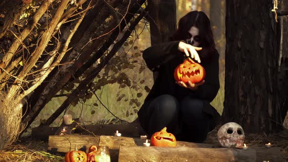 Witch with Santa Muerte Makeup Holding Pumpkin and Moving Hands