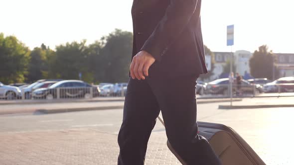 Crane Shot of Young Businessman Walking on City Street with His Luggage After Flight. Successful