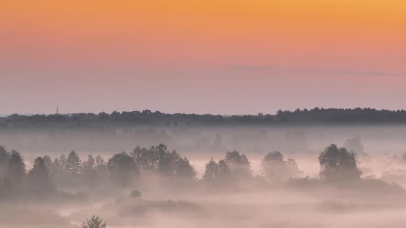 Amazing Sunrise Over Misty Landscape. Scenic View Of Foggy Morning Sky With Rising Sun Above Misty